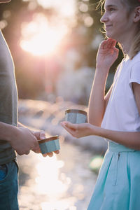 Midsection of siblings having food while standing outdoors