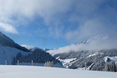 Snow covered kitzbueheler horn, austrian alps. clouds hang over the valley and the mountain ranges.