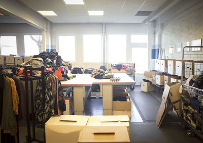 Various clothes and objects with boxes in brightly lit workshop