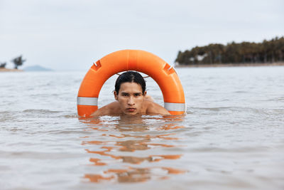 Portrait of young woman swimming in sea