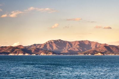 Scenic view of sea and mountains against sky