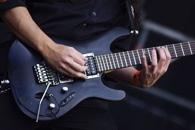 Midsection of man playing guitar