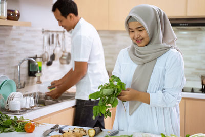 Young woman holding food while standing at home