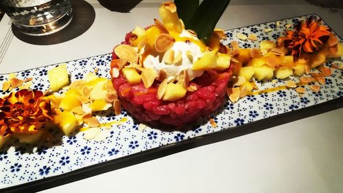 High angle view of chopped fruits in plate on table