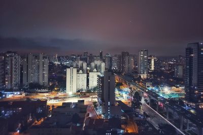 High angle view of illuminated buildings against sky at night