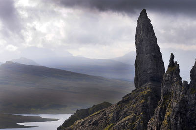 Rock formations and mountains against cloudy sky