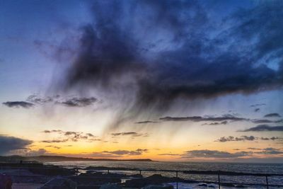 Scenic view of sea against dramatic sky during sunset