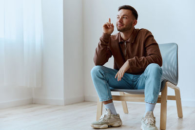 Young man sitting on sofa at home