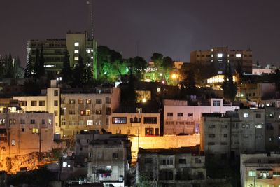 Illuminated cityscape against sky at night