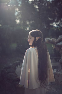 Woman looking away while standing in tree