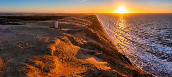 Rubjerg knude fyr lighthouse in sunset from drone