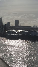 Boats in river with city in background