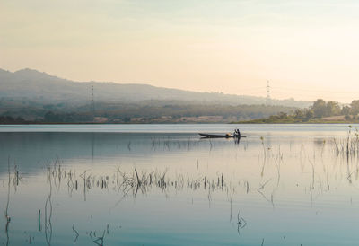 Local people sail the lake with his wooden boat in the morning atmosphere. morning view and mountain 