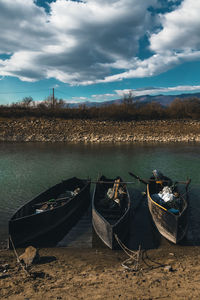 Boats moored on shore against sky