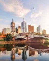 Princes bridge over the yarra river next to flinders street station against sky in melbourne city