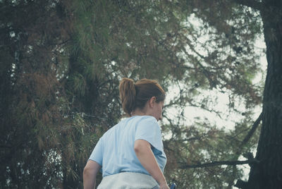 Rear view of girl standing in forest