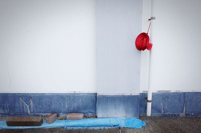 Red umbrella against blue wall at home