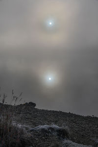 Scenic view of sun shining through clouds