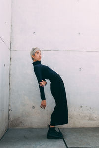 Portrait of woman standing against wall