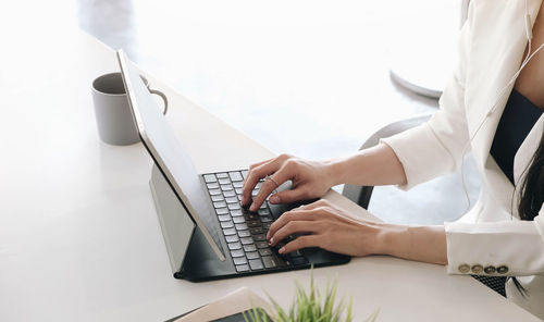 Midsection of woman using laptop on table