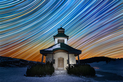 Illuminated building against sky during winter at night