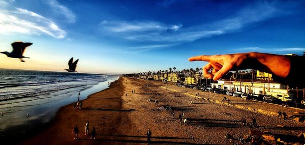 Person on beach against sky during sunset