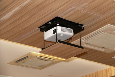 Low angle view of projection equipment attached to ceiling in conference room