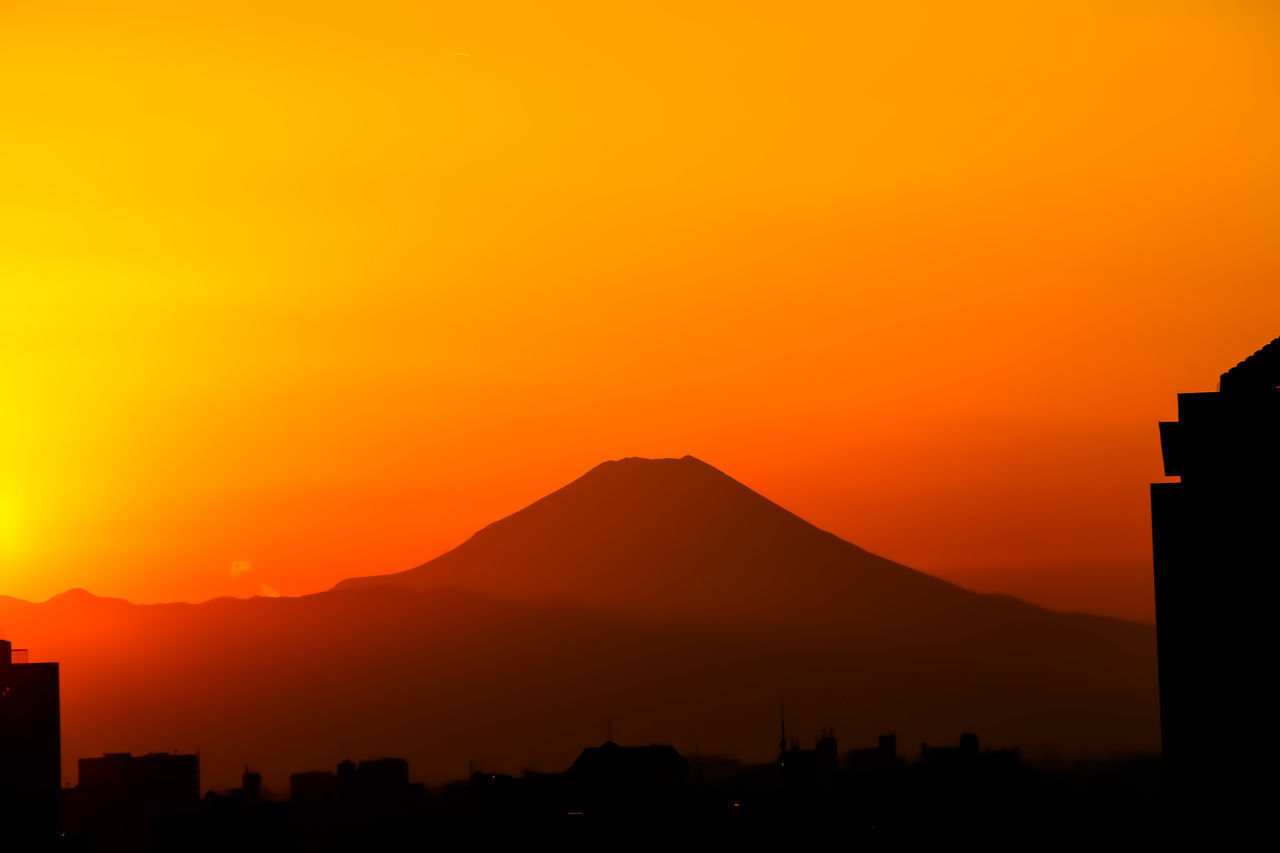 SILHOUETTE MOUNTAINS AGAINST ORANGE SKY