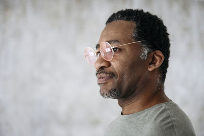 Thoughtful mature man wearing pink glasses