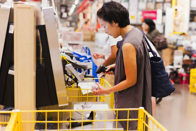 Woman consumerism scanning at the sef service counter in furniture store.