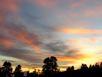 Silhouette trees against sky at sunset