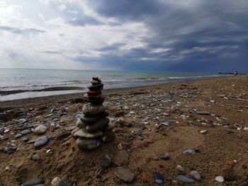 Stack of stones on beach against sky