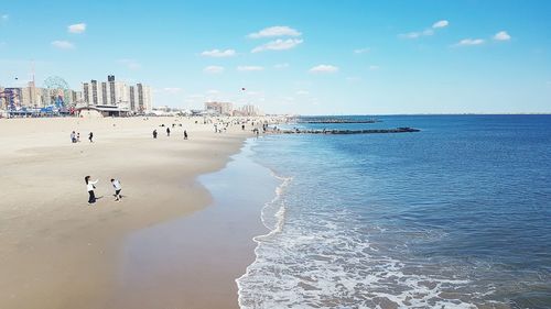 Panoramic view of people on beach against sky