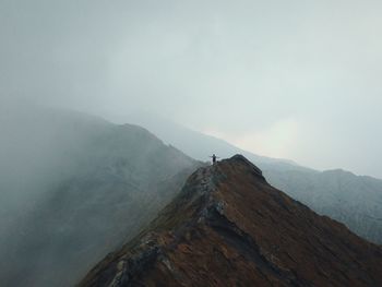 Man standing on mountain against sky