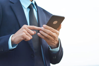 Midsection of man using mobile phone