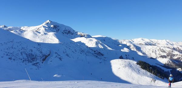 Scenic view of snowcapped mountains against clear blue sky