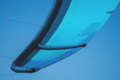 Low angle view of parachute against clear blue sky