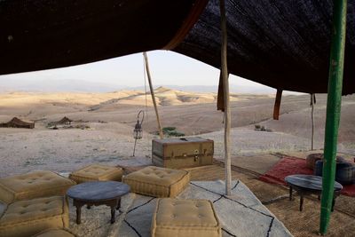 Empty chairs on landscape against sky