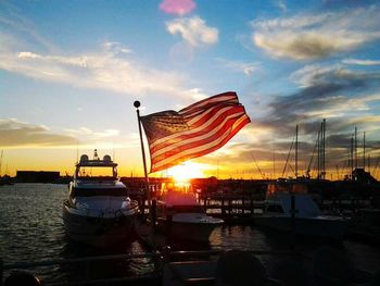 Boats in sea at sunset