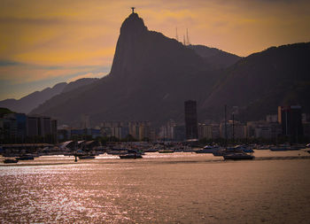 Sugarloaf mountain by guanabara bay against sky during sunset