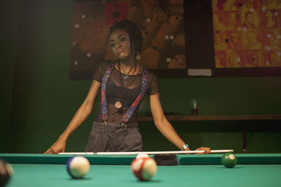 A young woman playing pool.