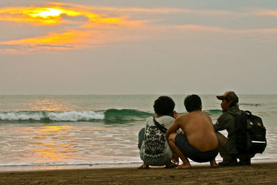 Rear view of couple sitting on beach