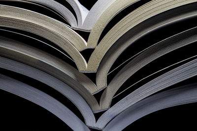 Close-up of books stacked against black background