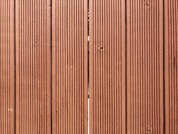 Full frame shot of patterned red-brown wooden wall background for design use