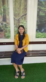 Portrait of young woman sitting on field