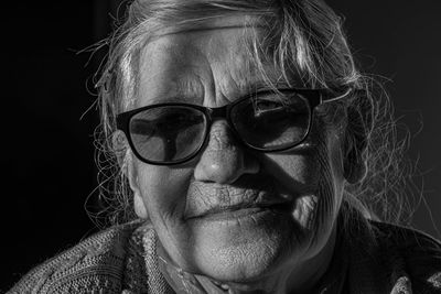 Close-up portrait of woman wearing mask against black background