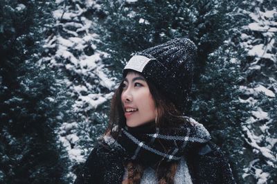 Portrait of woman in snow against trees
