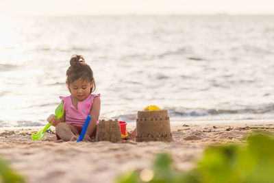 Full length of cute girl making sandcastle at beach