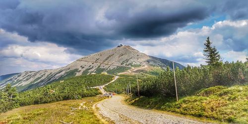 Road leading towards mountains against sky