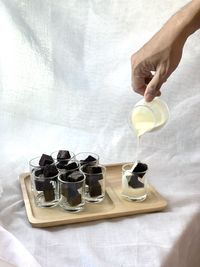 Hand holding ice cream cone on table